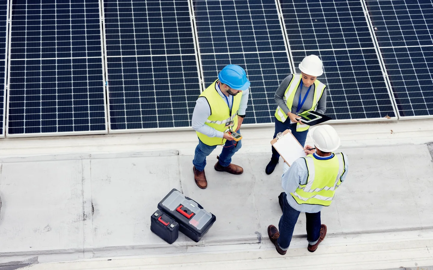 Professional solar installation team inspecting rooftop photovoltaic panels for safety and quality