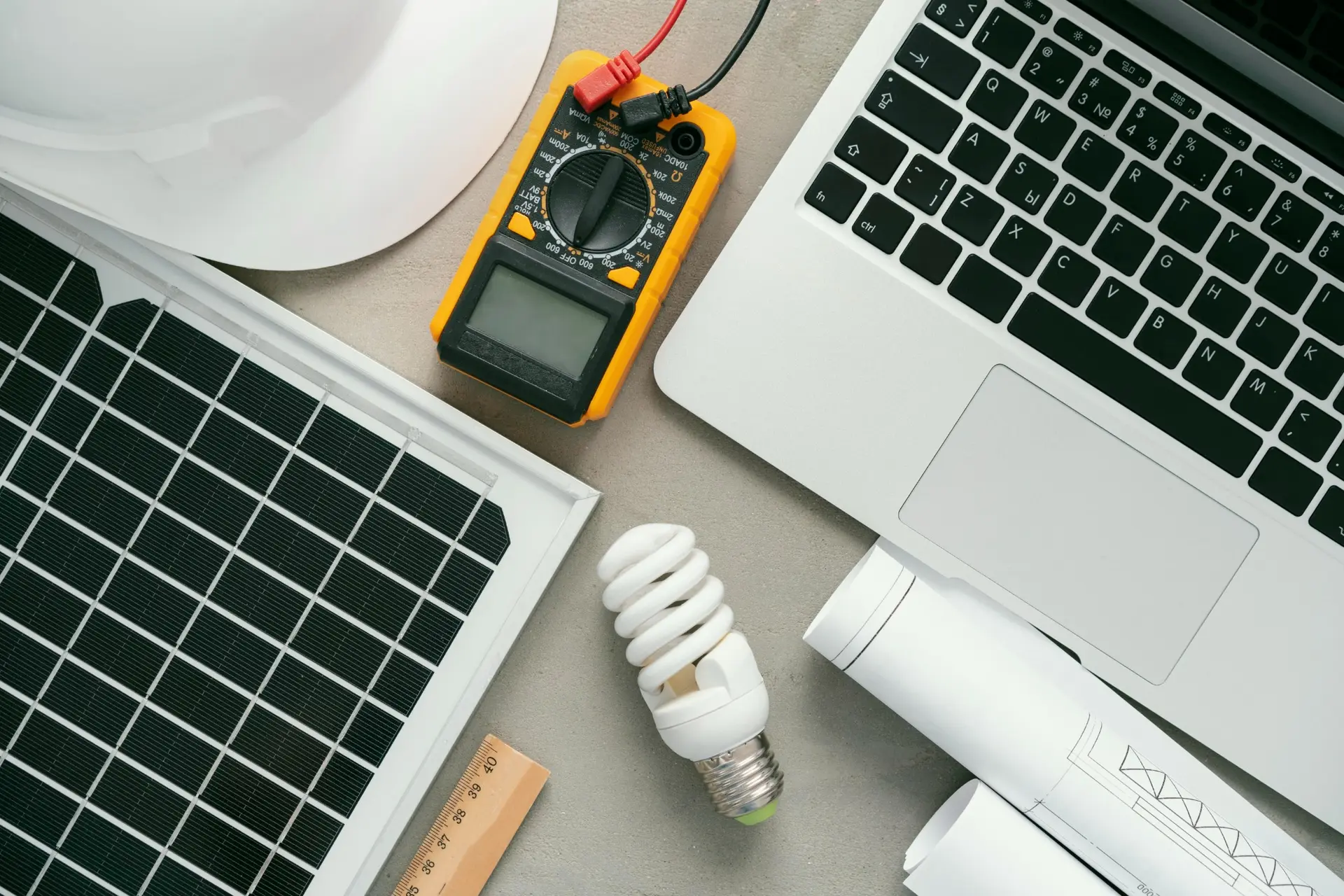 Detailed solar project assessment with photovoltaic panel, electrical meter and engineering laptop