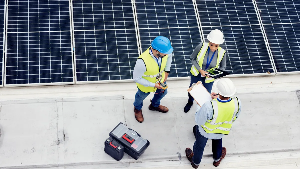 Commercial solar installation team inspecting rooftop photovoltaic panels