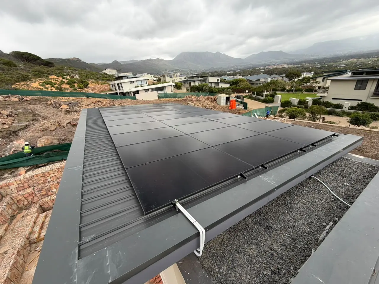 Completed photovoltaic array spanning a metal rooftop
