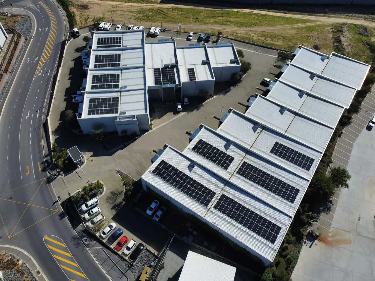 Aerial view of solar arrays installed across a multi-building commercial site