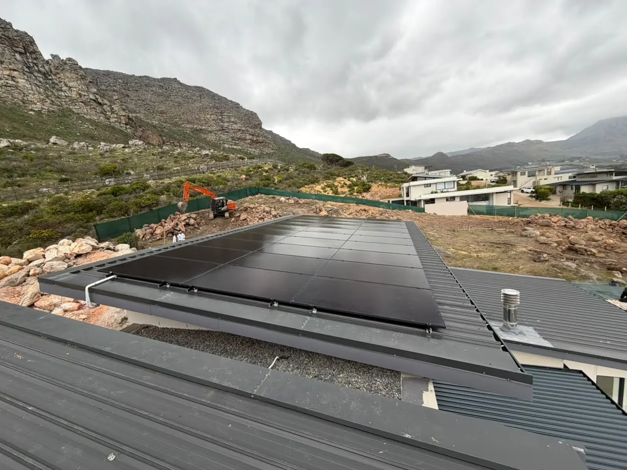 Roof-mounted solar panels installed beside mountain terrain